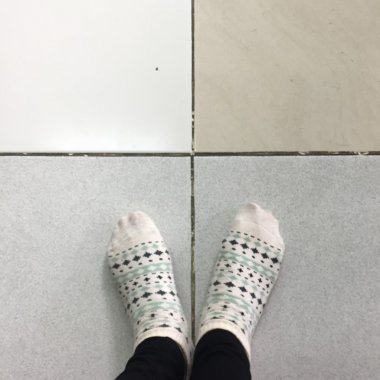 Selfie ayaklar giyme beyaz Polka Dot çorap üzerinde Çini zemin arka plan 