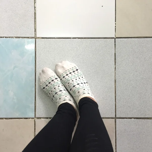 Selfie Pés vestindo branco Polka Dot meias no chão da telha fundo — Fotografia de Stock