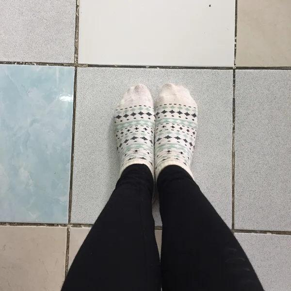 Selfie Feet visel fehér Polka dot zokni a csempe padló háttér — Stock Fotó