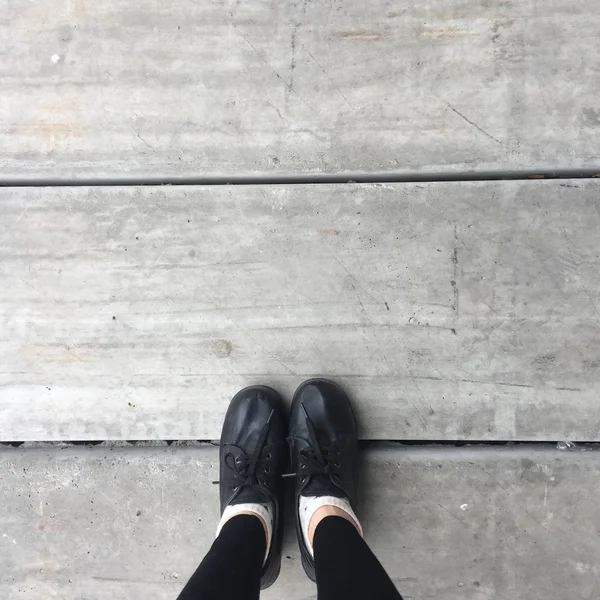 Selfie pés vestindo sapato preto para mulher no chão de fundo — Fotografia de Stock