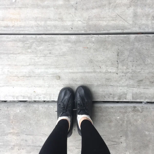 Selfie Feet portant une chaussure noire pour femme sur fond de sol — Photo