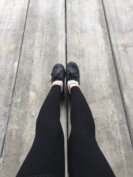 Selfie Feet portant une chaussure noire pour femme sur fond de sol — Photo