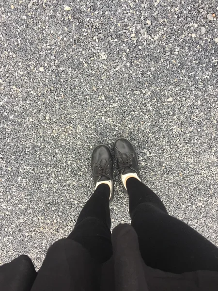 地板背景下女性的自脚穿黑鞋 — 图库照片