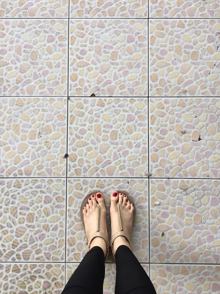 Vrouwelijke benen dragen schoeisel schoenen op vloer achtergrond — Stockfoto