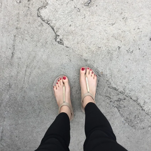 Női lábak viselése cipő cipő vagy flip-flop kültéri piros szeg a padlón háttér — Stock Fotó