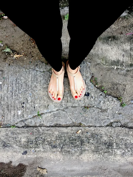 女腿穿着鞋鞋鞋或拖鞋户外红色指甲在地板背景 — 图库照片