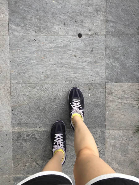 Běžecké boty. Barefoot běžecká obuv Closeup. Žena nosí sportovní boty na zemi nebo podlaze pozadí — Stock fotografie
