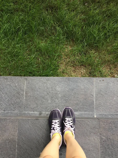Laufschuhe. Barfußlaufschuhe in Nahaufnahme. Frau trägt Sportschuhe auf Boden oder Boden Hintergrund — Stockfoto