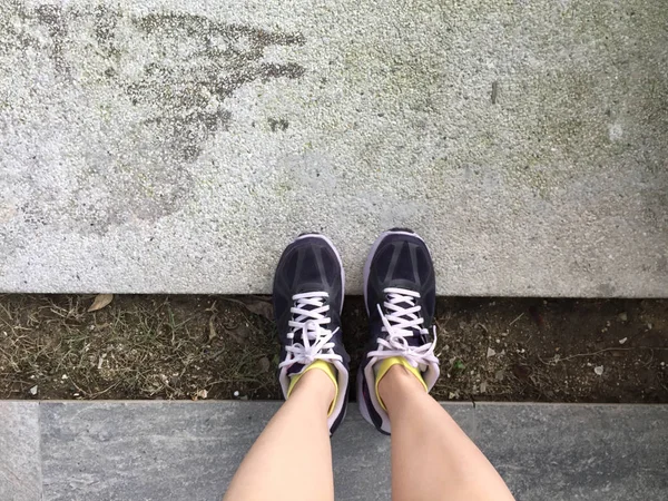 Chaussures de course. Chaussures de course pieds nus Gros plan. Femme portant des chaussures de sport sur fond de sol ou de plancher — Photo