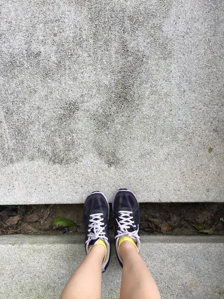 Běžecké boty. Barefoot běžecká obuv Closeup. Žena nosí sportovní boty na zemi nebo podlaze pozadí — Stock fotografie