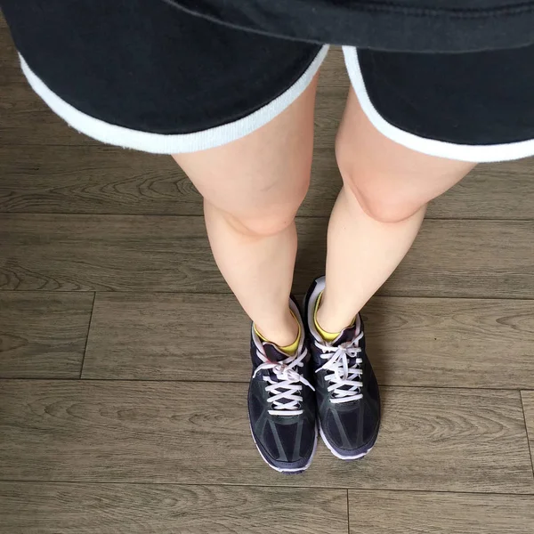 Loopschoenen. Barefoot running schoenen close-up. Vrouw dragen van sportschoenen op houten achtergrond — Stockfoto