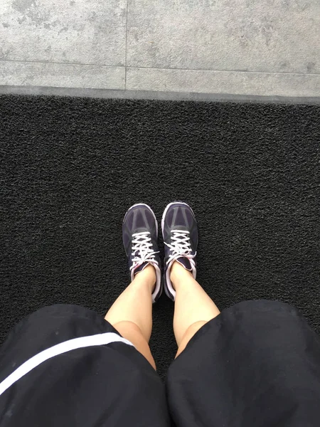 Sapatos de corrida. Sapatos de corrida descalços Closeup. Mulher vestindo sapatos esportivos no tapete — Fotografia de Stock