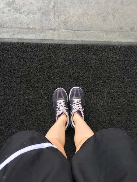 Běžecké boty. Barefoot běžecká obuv Closeup. Žena nosí sportovní obuv na koberec — Stock fotografie