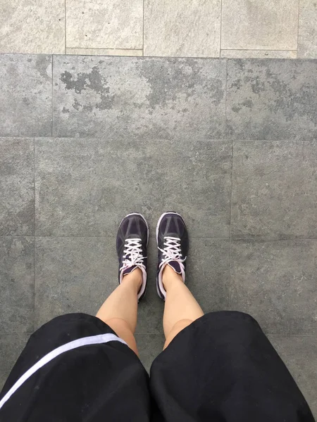 Παπούτσια για τρέξιμο. Ξυπόλητοι τρέχοντας παπούτσια κινηματογράφηση σε πρώτο πλάνο. Γυναίκα που φοράει αθλητικά παπούτσια στο φόντο των πλακιδίων — Φωτογραφία Αρχείου
