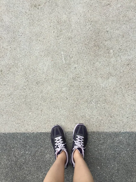 Sapatos de corrida. Sapatos de corrida descalços Closeup. Mulher vestindo sapatos esportivos no chão ou piso de fundo . — Fotografia de Stock