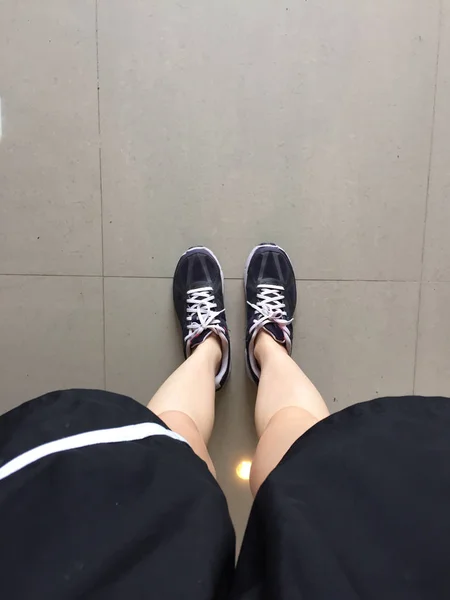 Loopschoenen. Barefoot running schoenen close-up. Het dragen van sportschoenen op tegel achtergrond vrouw — Stockfoto