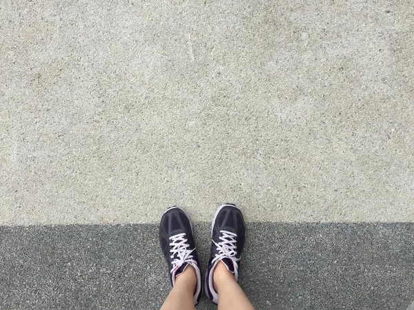 Laufschuhe. Barfußlaufschuhe in Nahaufnahme. Frau trägt Sportschuhe auf Boden oder Boden Hintergrund. — Stockfoto