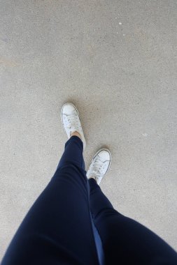 Kot ve beyaz spor ayakkabı sokaklarda genç kadın moda 