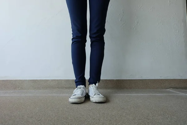 Moda giovane donna in blue jeans e scarpe da ginnastica bianche per le strade — Foto Stock