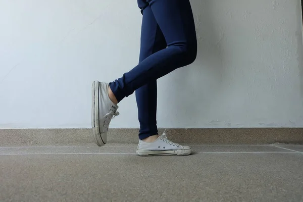 Moda giovane donna in blue jeans e scarpe da ginnastica bianche per le strade — Foto Stock