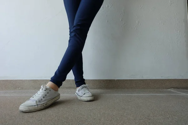 De jonge vrouw mode in blauwe Jeans en witte Sneakers op straat — Stockfoto