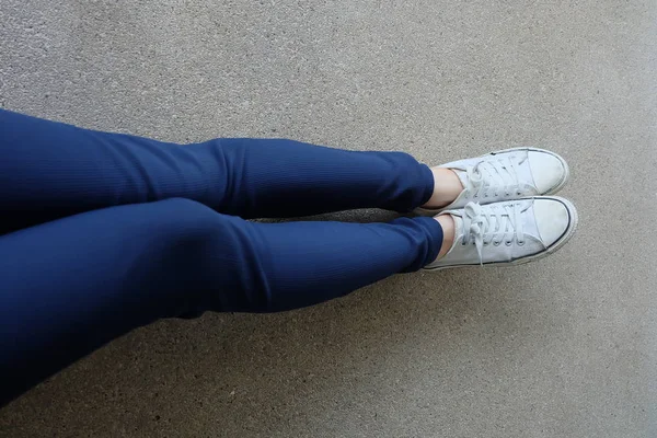 Mode junge Frau in blauen Jeans und weißen Turnschuhen auf der Straße — Stockfoto