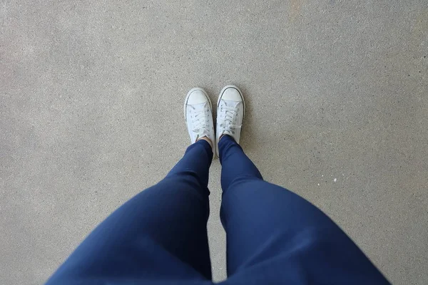 Młoda kobieta moda w niebieskie jeansy i białe trampki na ulicach — Zdjęcie stockowe