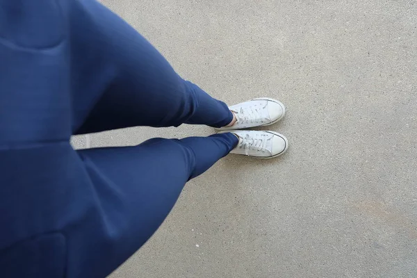 Moda mujer joven en pantalones vaqueros azules y zapatillas blancas en las calles —  Fotos de Stock