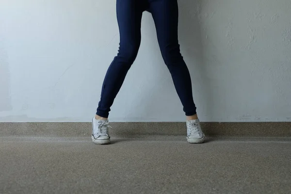 Молода жінка моди в синіх джинсах і білі кросівки на вулицях — стокове фото