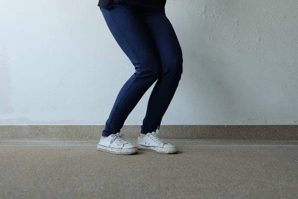 Młoda kobieta moda w niebieskie jeansy i białe trampki na ulicach — Zdjęcie stockowe