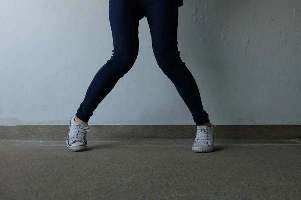 Moda mujer joven en pantalones vaqueros azules y zapatillas blancas en las calles —  Fotos de Stock