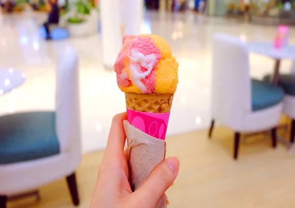 Main tenant un cône de crème glacée de framboise, fraise aux fruits — Photo