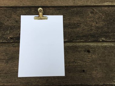 Ciltçi klibini ve ahşap arka plan üzerinde kağıt yığını