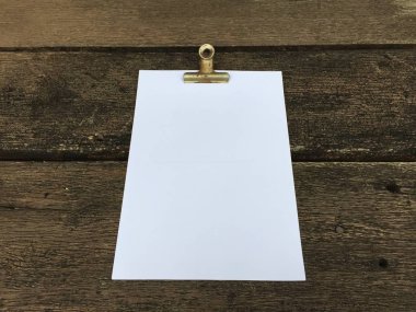 Ciltçi klibini ve ahşap arka plan üzerinde kağıt yığını