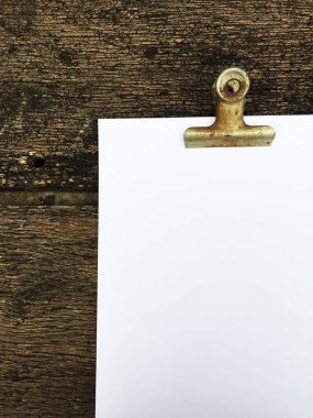 Ciltçi klibini ve ahşap arka plan üzerinde kağıt yığını