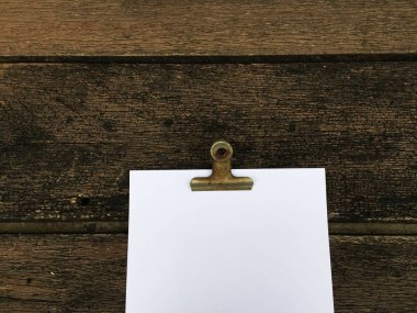 Ciltçi klibini ve ahşap arka plan üzerinde kağıt yığını