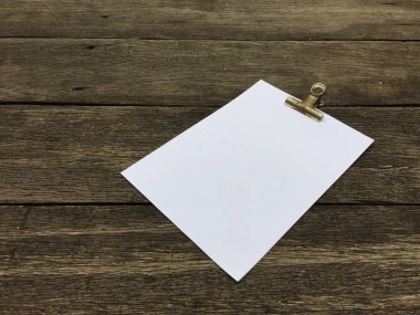 Ciltçi klibini ve ahşap arka plan üzerinde kağıt yığını