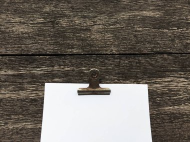 Ciltçi klibini ve ahşap arka plan üzerinde kağıt yığını