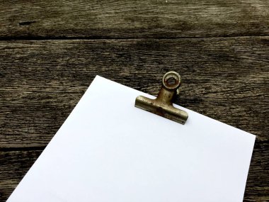 Ciltçi klibini ve ahşap arka plan üzerinde kağıt yığını