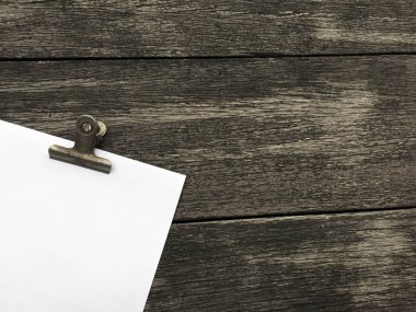 Ciltçi klibini ve ahşap arka plan üzerinde kağıt yığını