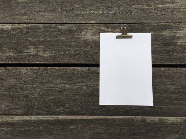 Ciltçi klibini ve ahşap arka plan üzerinde kağıt yığını