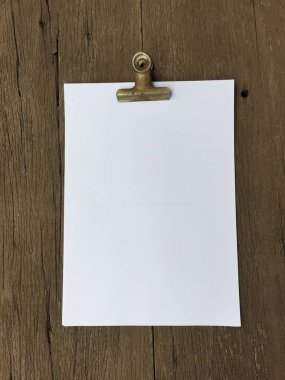 Ciltçi klibini ve ahşap arka plan üzerinde kağıt yığını