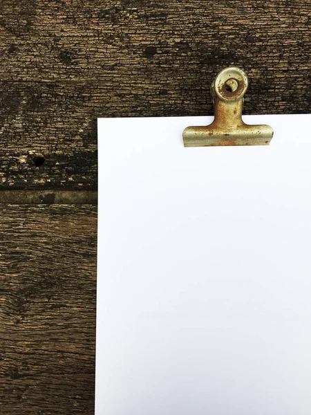 Ciltçi klibini ve ahşap arka plan üzerinde kağıt yığını