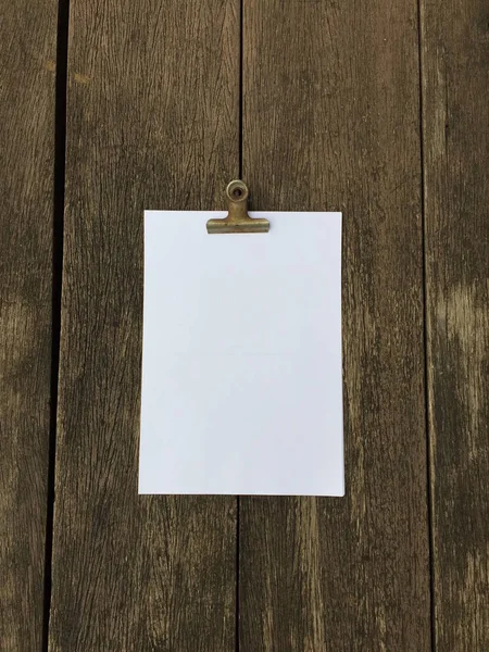 Ciltçi klibini ve ahşap arka plan üzerinde kağıt yığını