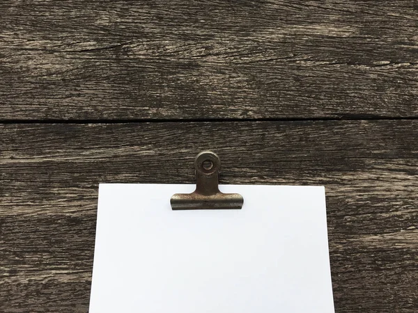 Ciltçi klibini ve ahşap arka plan üzerinde kağıt yığını