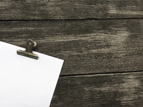 Ciltçi klibini ve ahşap arka plan üzerinde kağıt yığını