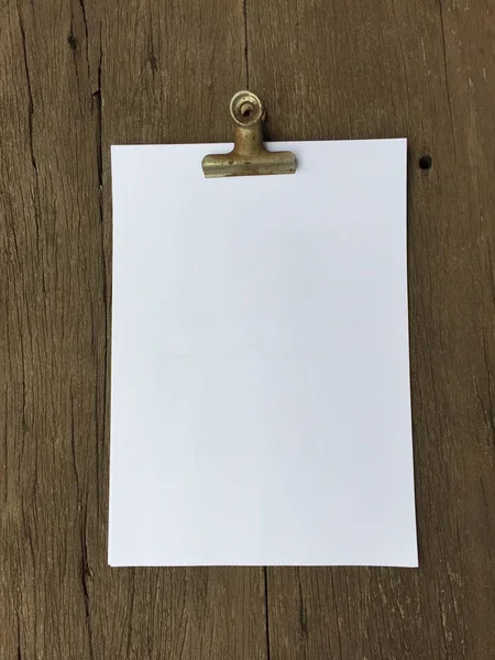 Ciltçi klibini ve ahşap arka plan üzerinde kağıt yığını