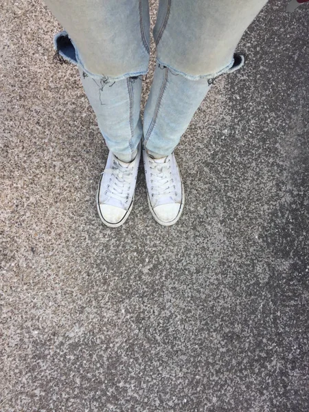 Woman's Legs in Blue Jeans and White Sneakers on Floor — Stock Photo, Image