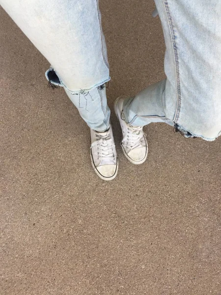 Woman's Legs in Blue Jeans and White Sneakers on Floor — Stock Photo, Image