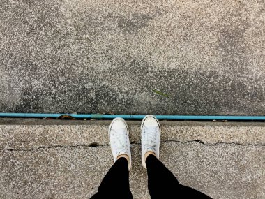 Genç moda kadının bacakları ile spor ayakkabı, kat arka plan üzerinde beyaz Ayakkabı 